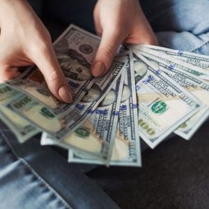 Person holding $100 bills