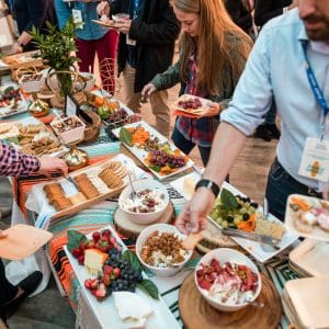 People serving themselves from a conference buffet illustrating catering cost-saving strategies for meetings and events.